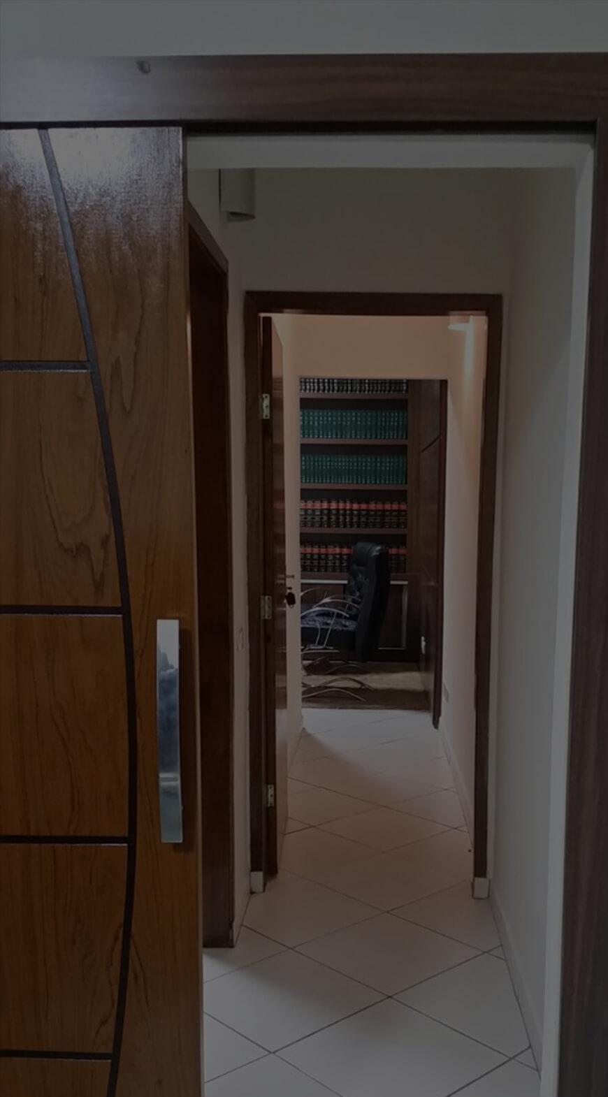 Entrada do escritório em Astorga, com biblioteca jurídica ao fundo.